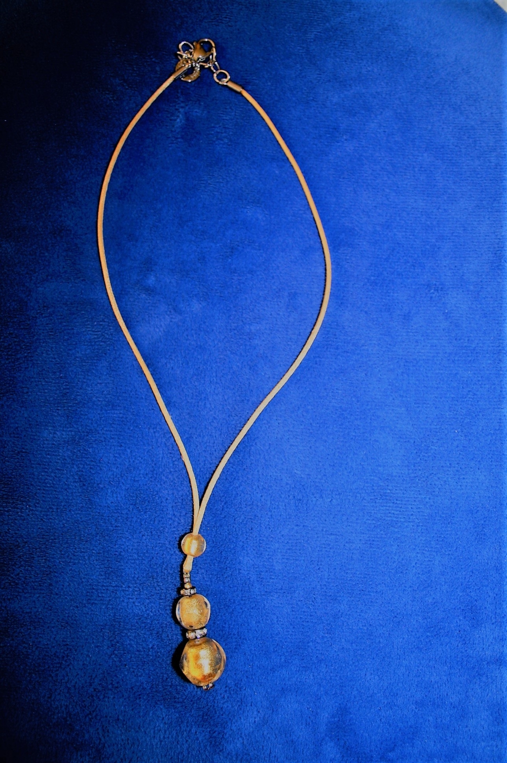 Halskette mit goldfarbener Kordel und Glasanhänger mit Schmucksteinchen