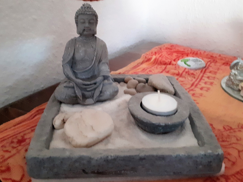 Buddha-Arrangement mit Zen-Garten und Kerze
