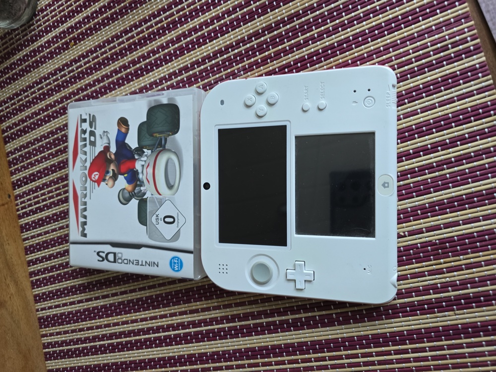 Nintendo 2DS mit einem Spiel und Ladegerät 