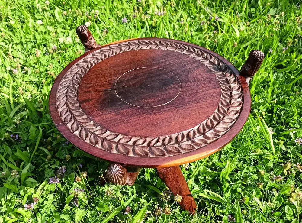 Malawi: Vintage Klapptisch mit geschnitzter Platte. Beistelltisch