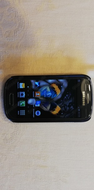 Samsung Galaxy S3 mini mit Hardcover, Ohrhörer, Verpackung.