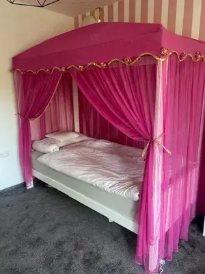 Zauberhaftes Himmelbett mit rosa Betthimel und goldener Krone
