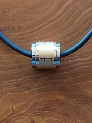 Schwarze Halskette mit einem tonnenförmigen Metall Anhänger