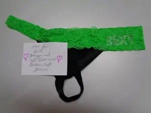 Erotischer String Slip getragen in schwarz mit grüner Spitze
