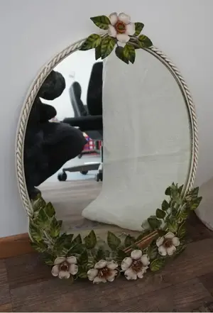 Wandspiegel mit ovalem Metallrahmen, floral verziert