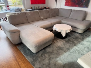 Hochwertiges Wohnzimmer-Sofa von HUKLA in silbergrauem Stoffbezug.