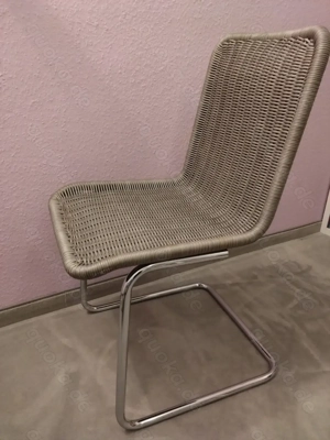 Schwingstuhl   Freischwinger,  Stahlchrom, Rattangeflecht in grau, mit Sitzkissen in beige