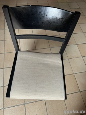 Schwarzer Holzstuhl mit beigem Polstersitz