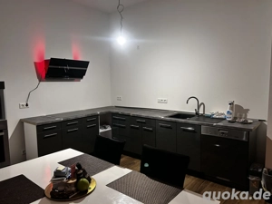 Küche mit Hängeschränken und Elektrogeräten 