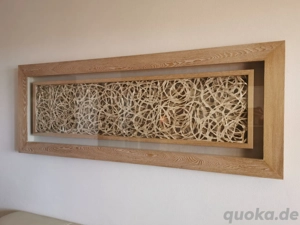 Bild aus Holzrahmen und Pflanzendeko hinter Glas