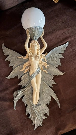 Wandleuchte im Jugendstil, die eine Elfe oder Fee darstellt.