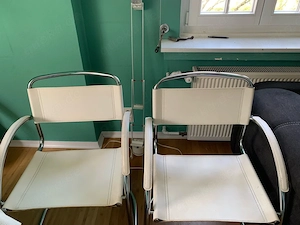 Weisse Stühle mit Metallgestell
