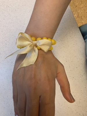 suße gelbe kunststof  armbaender mit goldgelber schleife