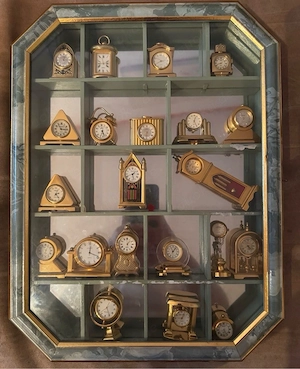 21 Miniatur Uhren aus Messing im Setzkasten