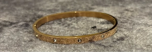 Goldiarbener Armreif mit Steinen
