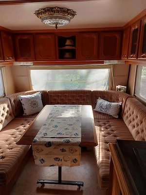 Wohnwagen mit massiven Holzvorbau auf Campinglatz zu verkaufen