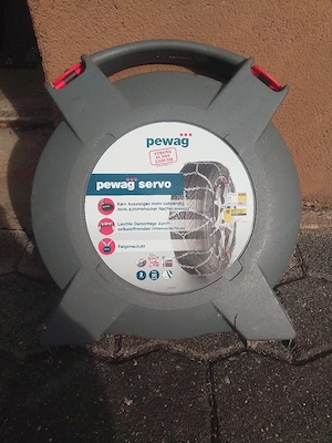 eine graue Transportbox mit pewag servo Schneeketten