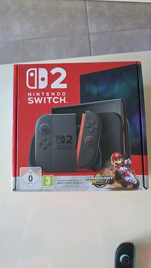 Schwarze Nintendo Switch 2 Handheld-Konsole mit blauen orangenen Joy-Con-Controllern und Zubehör