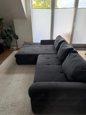 Graues Ecksofa mit Schlaffunktion und Bettkasten 