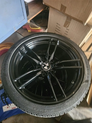 4 Kompletträder mit schwarzen Felgen und BMW-Nabenkappen